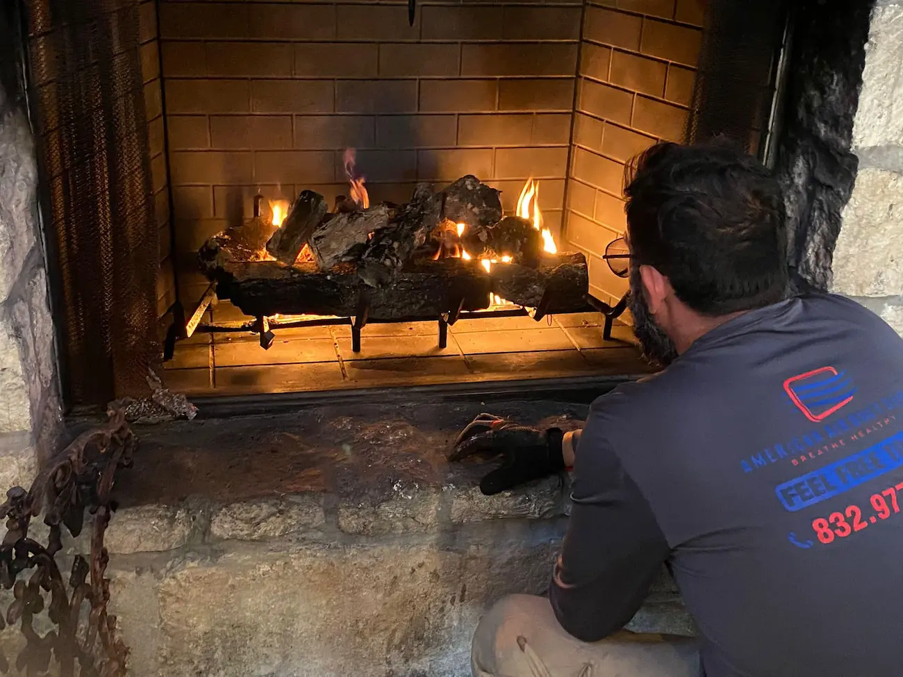Technician servicing a fireplace at American Air Duct Services
